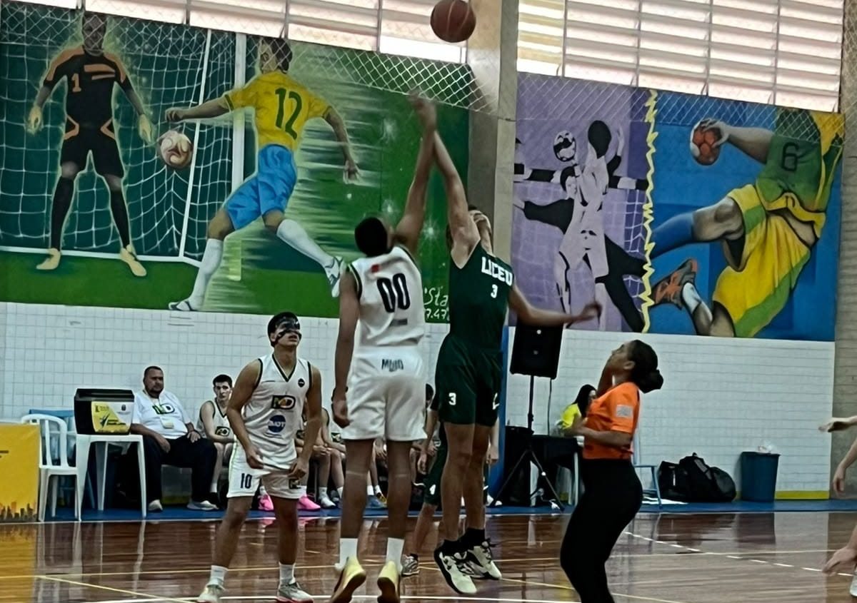 Alunos do Colégio Liceu Olímpia disputando a bola no início de uma partida de basquete, na quadra da escola
